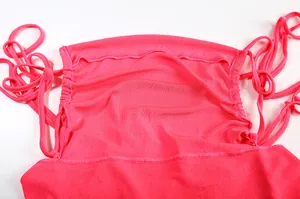 Close-up of a vibrant pink summer dress detail with gathered fabric and ties.