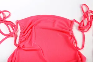 Detail of the ruched side design and halter ties on a vibrant pink summer dress