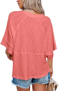 Back view of women's loose coral pink T-shirt with bell sleeves and patchwork detail