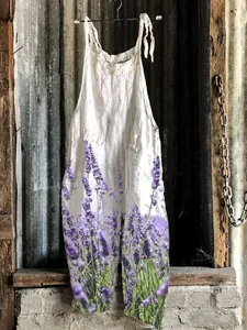 Detailed macro view of white linen jumpsuit featuring a vibrant lavender floral print.