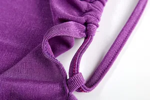 Close-up view of the stitching and fabric texture of a purple halter neck backless dress.