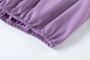 Détail macro du tissu violet de haute qualité avec ourlet élastiqué et couture précise.