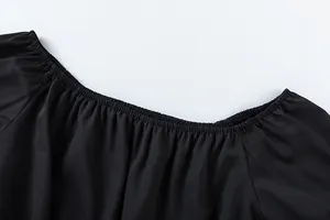 Vue détaillée de l'encolure élastique à épaules dénudées sur ce haut noir décontracté