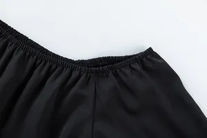 Vue détaillée de la ceinture élastique d'un pantalon noir à taille haute fluide.
