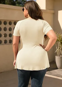 Back view of a plus size cream-colored short sleeve T-shirt in outdoor sunlight
