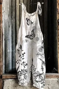 Detailed view of white vintage jumpsuit with floral and butterfly line art prints