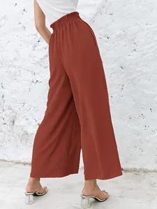 Back view of high-waisted terracotta wide-leg pants with elastic pleated waistband detail