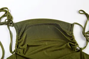 Detailed macro view of olive green halter dress neckline featuring elegant pleated fabric texture
