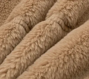 Macro view showing the soft and dense texture of tan faux rabbit fur winter coat