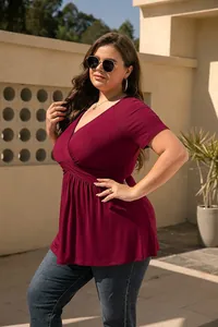 Side view of a plus size woman wearing a burgundy V-neck top and jeans