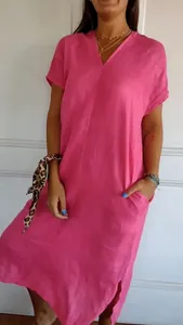 Close-up detail of a loose pink cotton linen dress showing V-neckline and short sleeves.