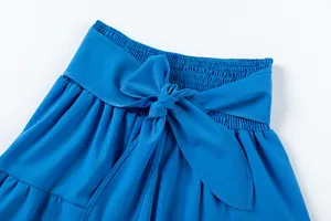 Détail du pantalon bleu à taille haute avec taille froncée et ceinture à nœud