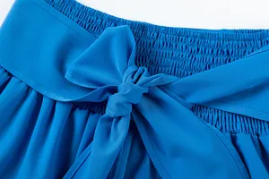 Gros plan d'un pantalon bleu taille haute avec une taille smockée et un nœud élégant