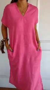 Close-up detail showing the loose fit of a pink cotton linen V-neck dress with pockets.