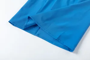 Gros plan de l'ourlet d'un pantalon large bleu montrant la couture et la texture