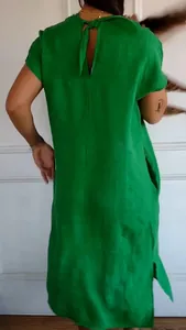 Back view of a loose green cotton linen short sleeve dress with elegant neck tie detail