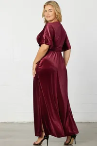 Elegant burgundy velvet maxi dress with short sleeves, a flowing skirt, and a cinched waist.