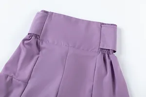 Gros plan sur la taille haute élastiquée d'un pantalon violet à jambes larges.