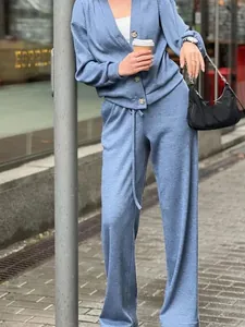 Full body street style view of a blue knit cardigan and wide-leg pants lounge set