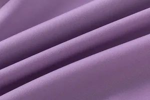 Détail en gros plan d'un tissu tissé violet montrant une texture diagonale fine.