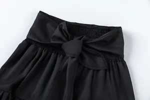 Gros plan d'un pantalon noir à taille haute avec taille élastique et grand nœud.