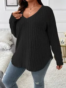 Détail du haut noir grande taille à col en V montrant le tissu côtelé et la coupe décontractée