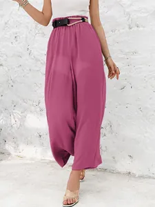 Close-up detail of high-waisted magenta wide-leg pants featuring a unique belt accent