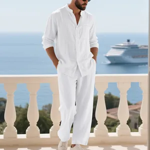 Modelo con camisa de lino blanco y pantalón holgado en un balcón con vistas al mar
