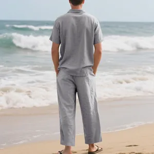 Vue de dos d'un homme en ensemble de loisirs en lin gris sur une plage ensoleillée