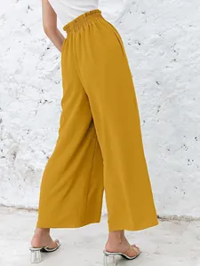 Back view of high waist mustard yellow wide leg pants with textured fabric