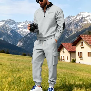 Outdoor-Detail eines grauen Herren-Trainingsanzugs mit Halbreißverschluss und Cargo-Jogginghose