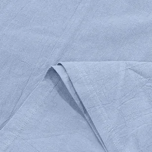 Vista macro de la textura de la tela de lino azul claro y detalles del dobladillo.