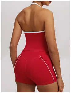 Back view of a red halter neck yoga set showing white piping detail on top and shorts