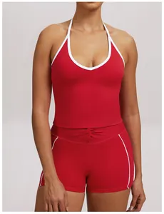 Detailed view of women's red halter neck yoga tank top and sports shorts with white piping
