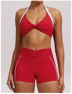 Detailansicht eines roten zweiteiligen Yoga-Sets mit Twist-Halter-Top und passenden Shorts.
