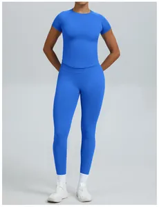 Volledig beeld van een vrouw in een blauwe naadloze yogaset met korte mouwen voor fitness.