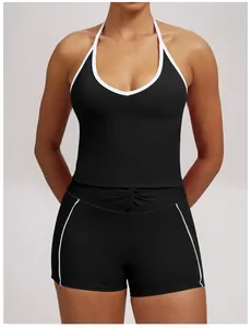 Detailed view of black halter yoga vest and shorts with white contrast piping