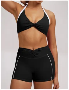 Detailaufnahme von schwarzen Yoga-Shorts und Halter-Top mit weißem Besatz und Twist-Detail