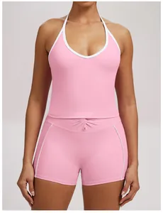 Front view of pink halter yoga tank top and matching shorts with white piping detail