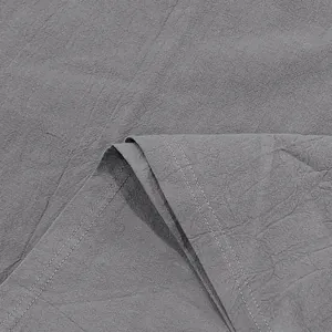 Close-up detail of gray linen fabric showing double-stitched hem and natural texture
