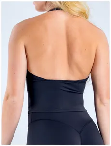 Detalle de camiseta de yoga negra con cuello halter y diseño de espalda descubierta.