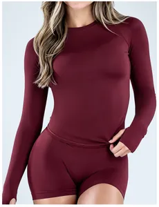 Detail of burgundy seamless long-sleeved sports shirt for fitness and yoga activities.