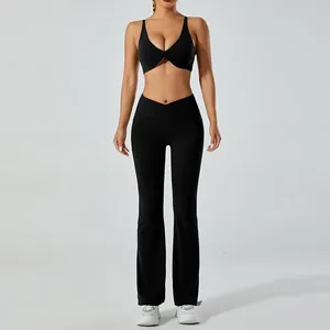 Ensemble de yoga noir deux pièces avec brassière torsadée et legging évasé taille haute.