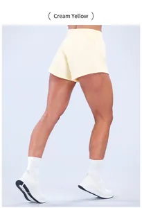 Dettaglio dei pantaloncini da yoga giallo crema ad asciugatura rapida con vestibilità comoda.
