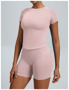Detailweergave van roze naadloze yogaset met korte mouwen en een korte broek met hoge taille