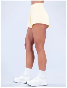 Vista laterale di pantaloncini da yoga giallo pallido ad asciugatura rapida per donna a vita alta
