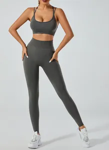Full-body view of a model in a dark grey two-piece high-waist yoga sports bra and leggings