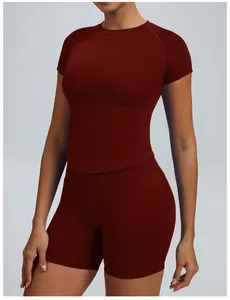 Detailweergave van naadloze bordeauxrode yogaset met top met korte mouwen en sportbroek
