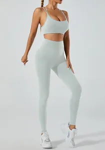 Detail showing the fit of mint green high-waist yoga leggings and strappy sports bra set.