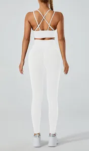 Back view of white yoga set with criss-cross sports bra and high-waisted gym leggings.